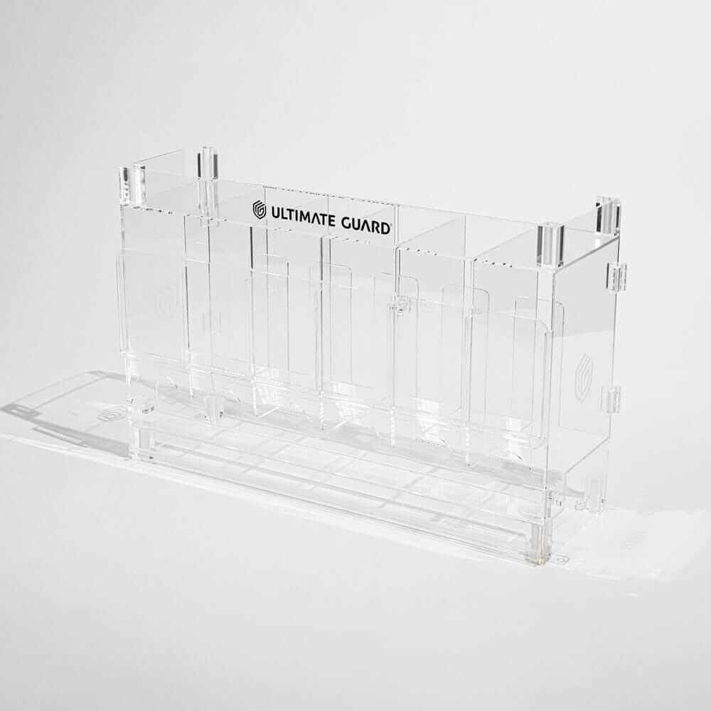 Accessoires Stackable and expandable dispenser for trading card booster packs, deck boxes and more. With high-quality 100% acrylic panels, 6 compartments and front slots for displaying booster packs and a top shelf for displaying accessories.- High qualit